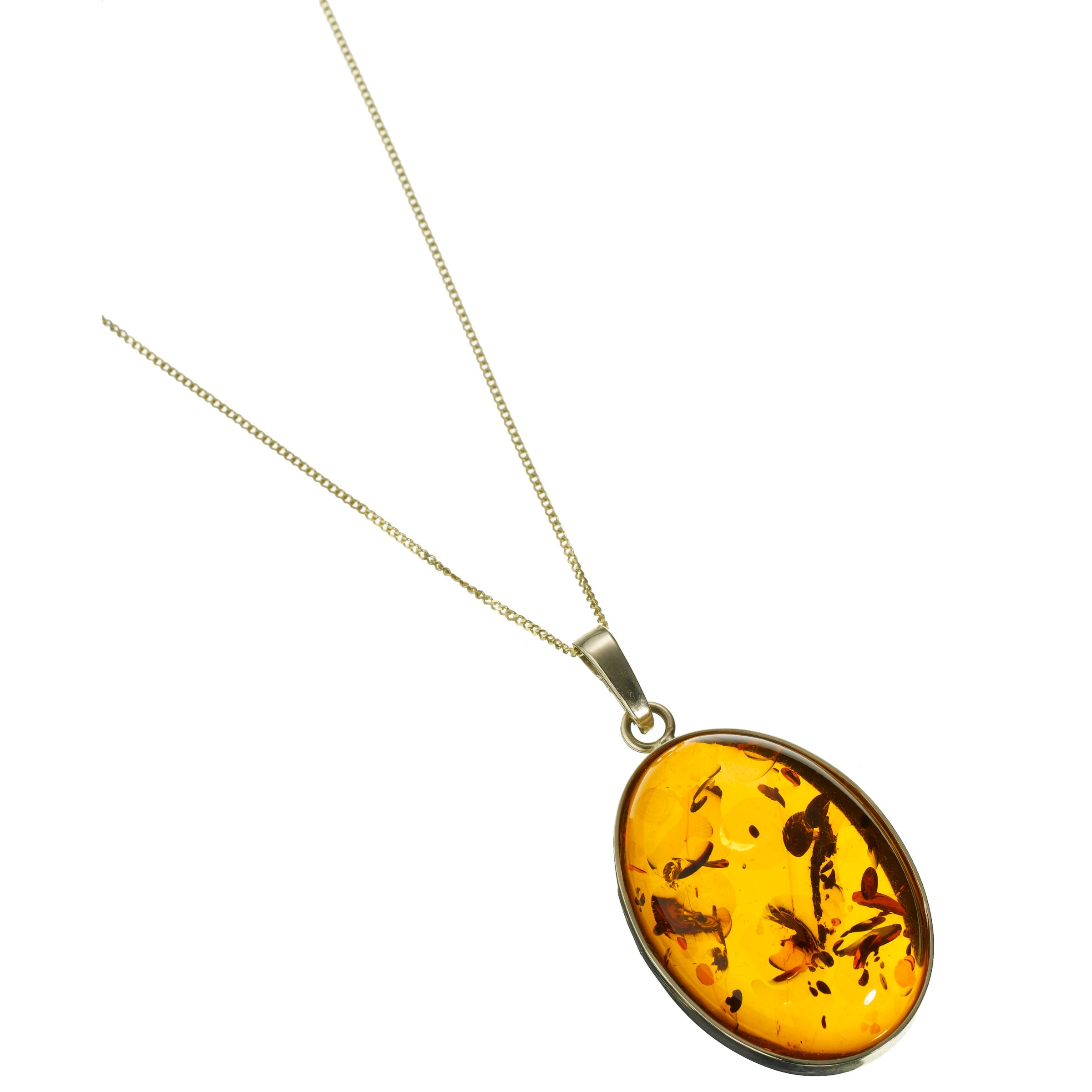 Embracing the notion that opposites attract, this stunning necklace combines a very delicate gold chain with a beautiful large pendant inset with domed natural amber.